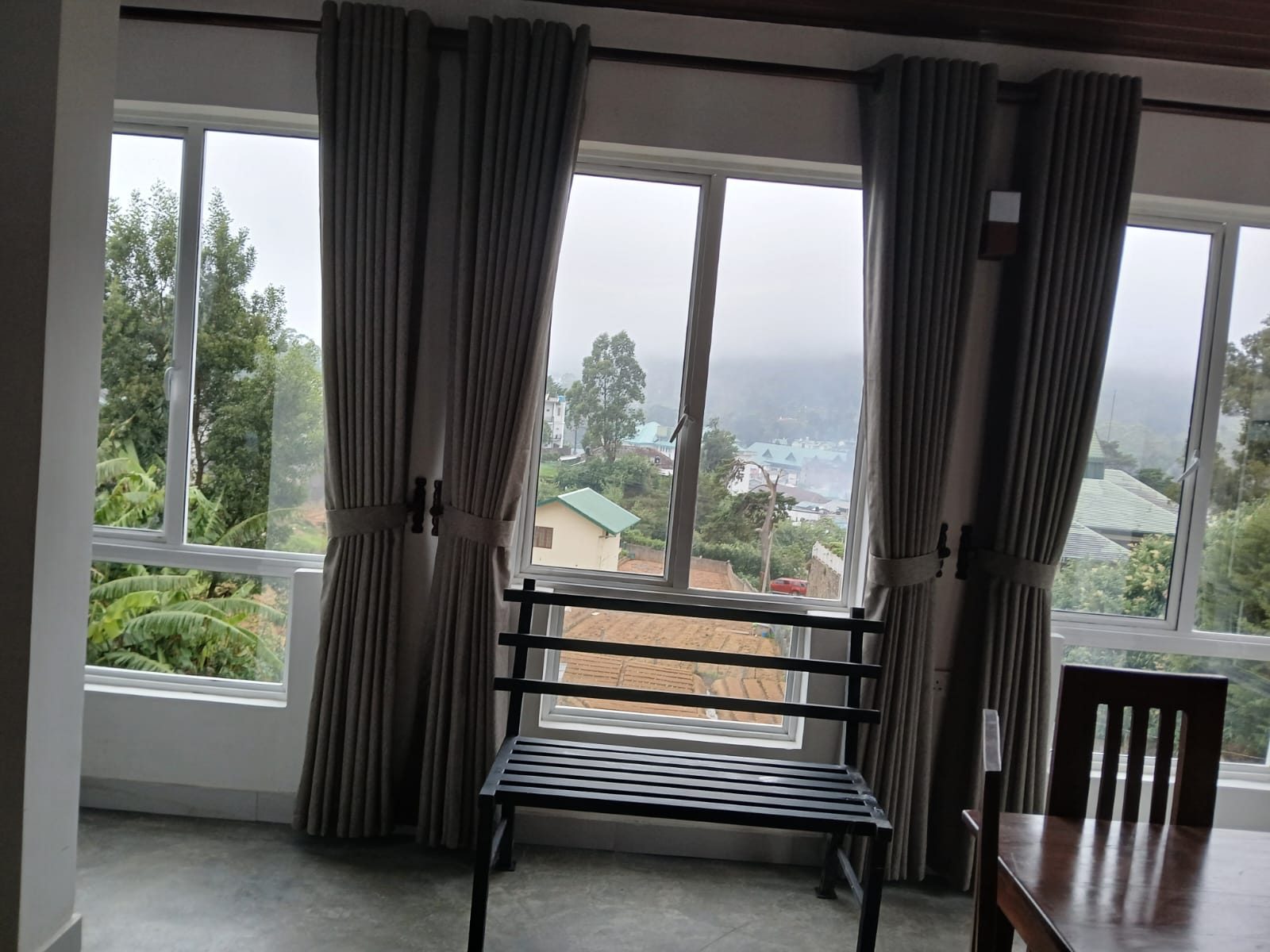 View from a room window over rooftops to the misty hills