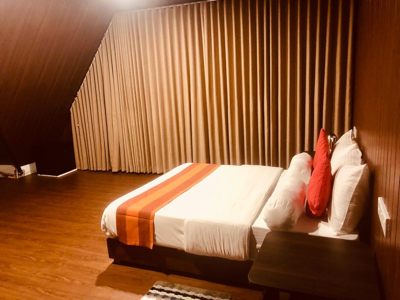 Double bed with red cushions against timber-effect panelling