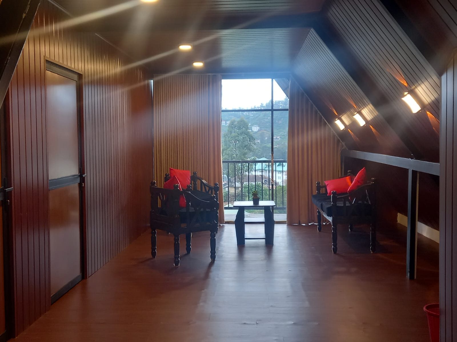 Balcony sitting area with wooden chairs facing the view