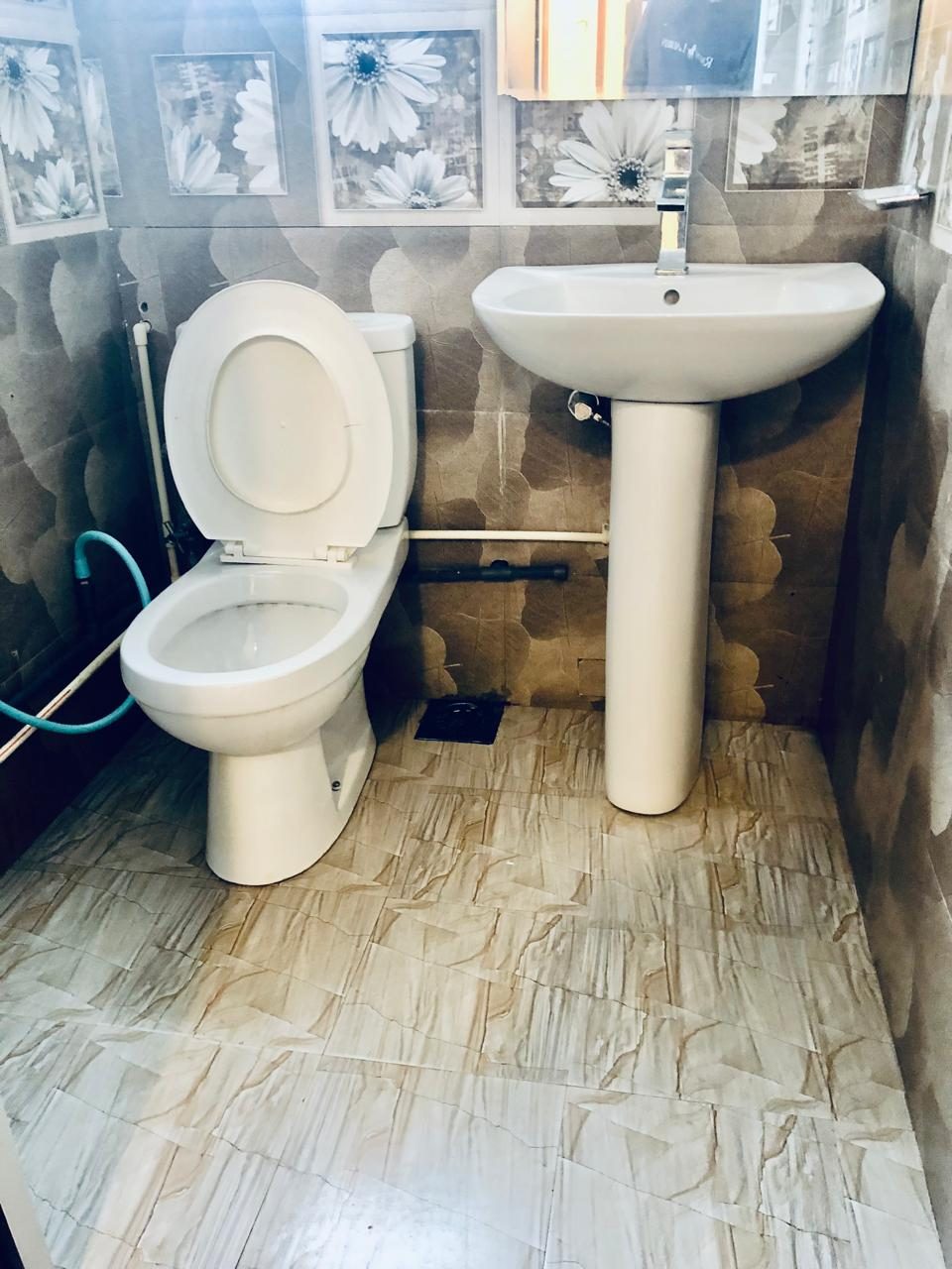 Bathroom with basin, toilet and floral tiles