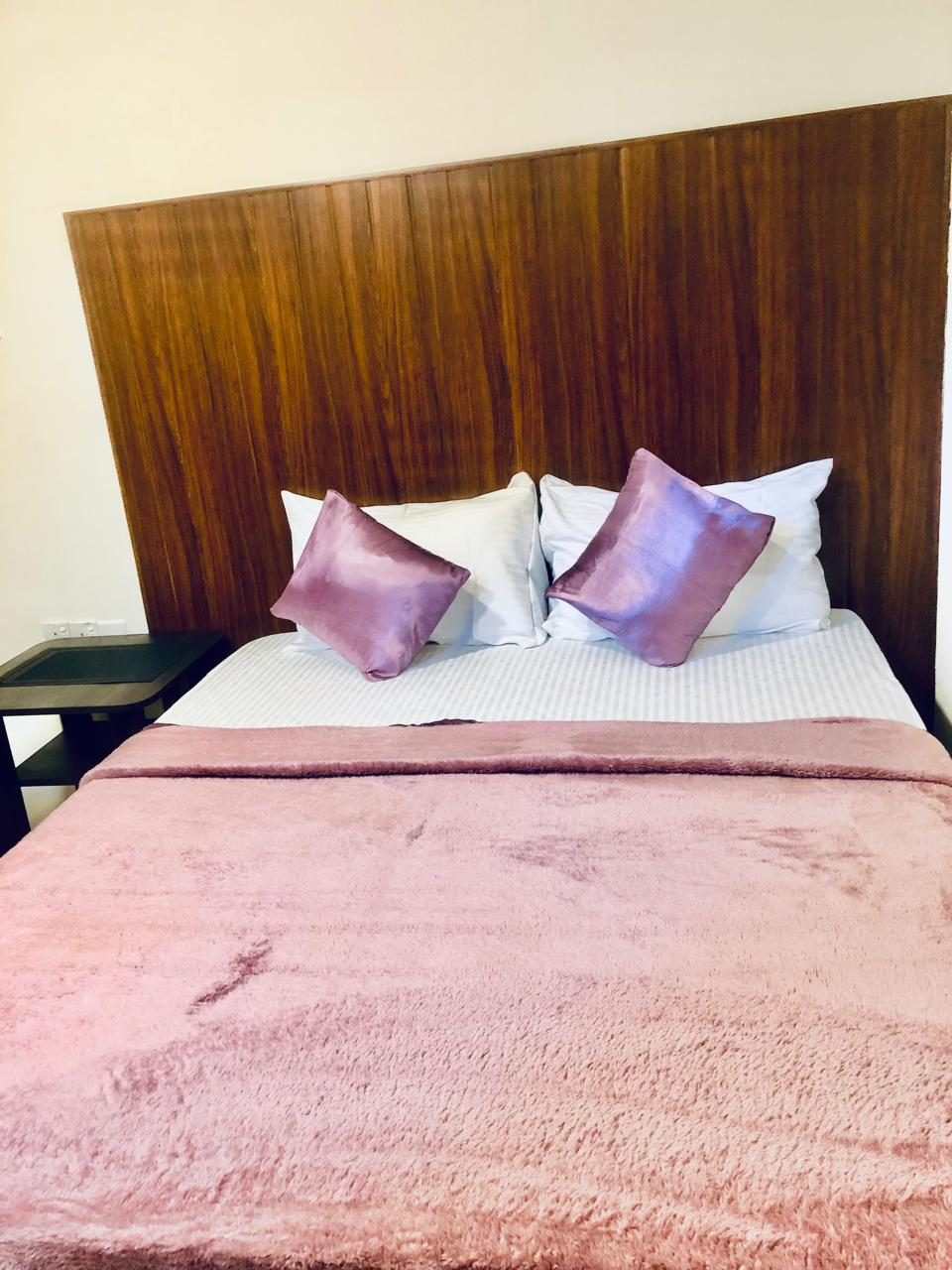 Double Room with Mountain View — large double bed with lilac cushions