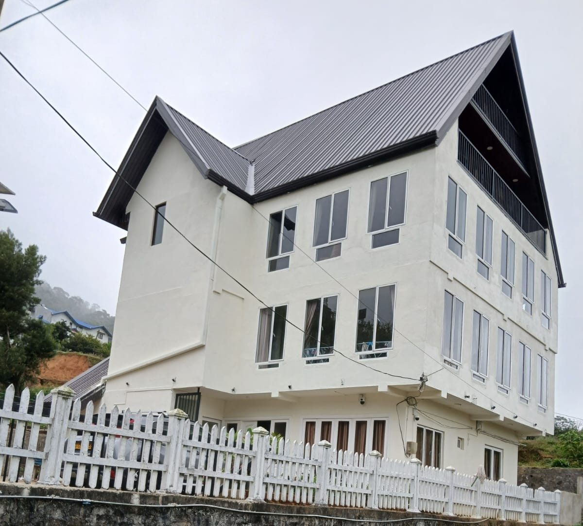 Scenic Hills — a tall white chalet with a steep dark roof and white picket fence