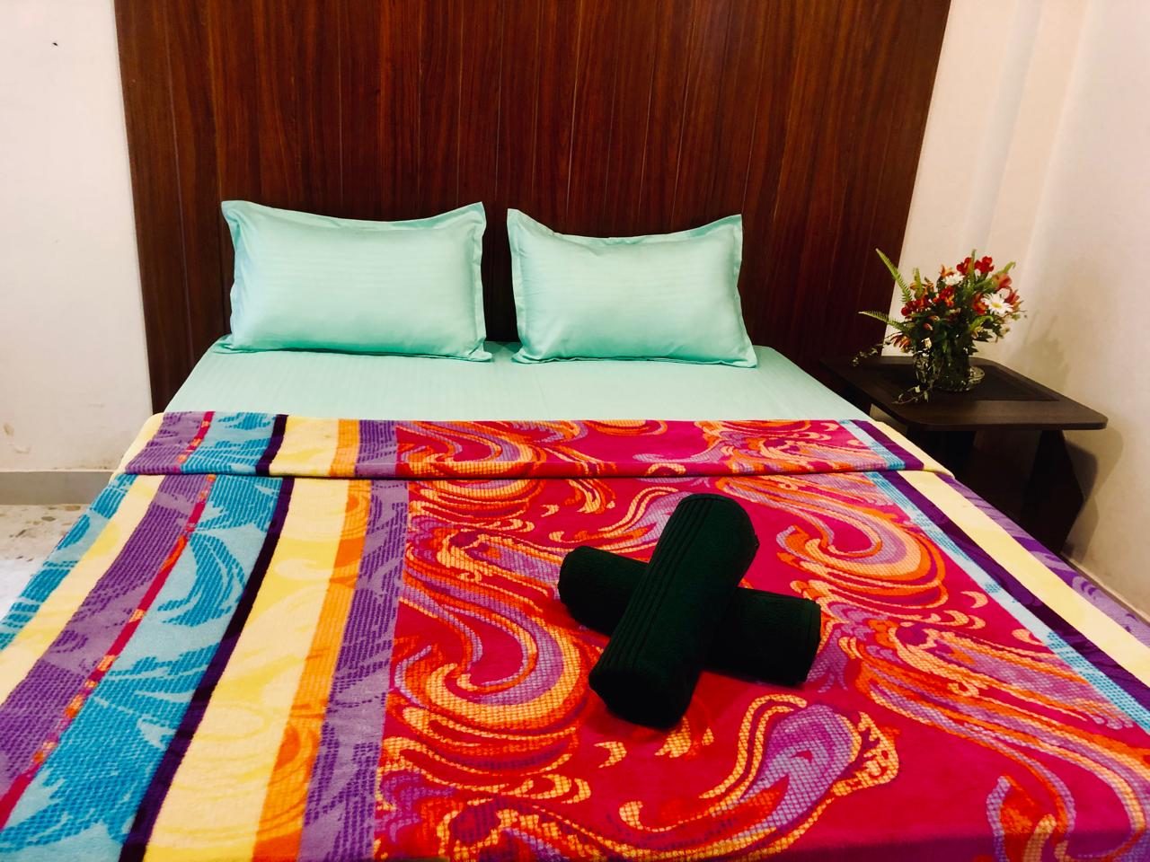 Deluxe Double Room with a bright patterned bedspread and teal pillows