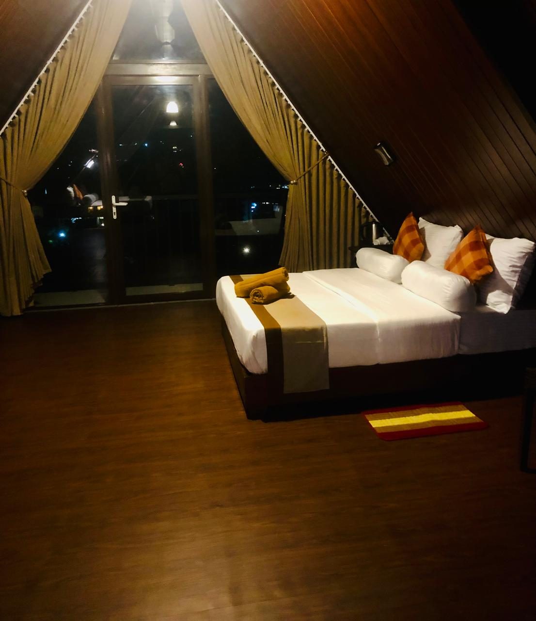 Cabana family room bed with the town lights beyond the balcony